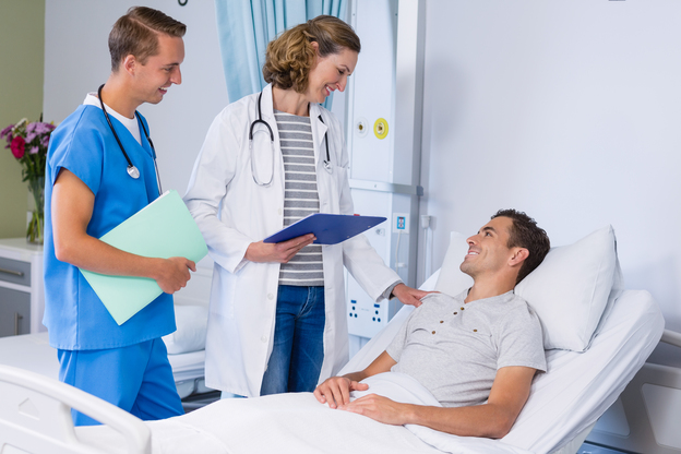 Médecins parlant au patient dans le lit d'hôpital